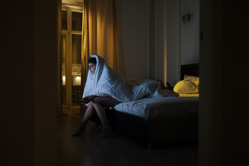 woman covered in a blanket on a bed