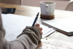 woman writing in a journal with coffee