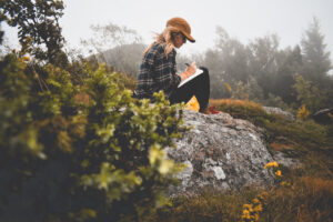 woman journaling on mountain